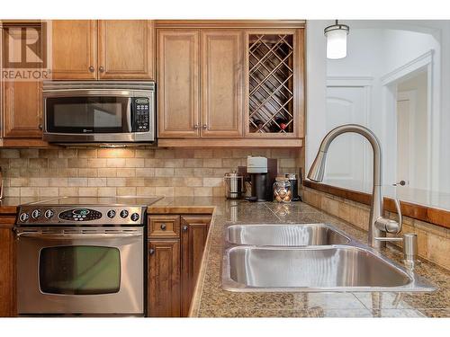 Beautiful kitchen with granite tile counters, eating bar, stainless steel appliances (newer fridge) - 2770 Auburn Road Unit# 201, West Kelowna, BC - Indoor Photo Showing Kitchen With Double Sink