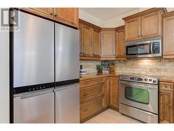 Beautiful kitchen with granite tile counters, eating bar, stainless steel appliances (newer fridge) - 