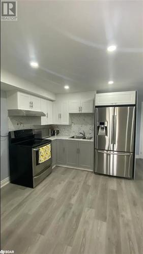 Kitchen featuring electric range, stainless steel fridge, white cabinetry, and sink - 896 John Street Street Unit# B2, Innisfil, ON - Indoor Photo Showing Kitchen With Double Sink