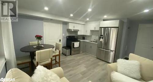 Kitchen with white cabinetry, sink, stainless steel appliances, light hardwood / wood-style floors, and decorative backsplash - 896 John Street Street Unit# B2, Innisfil, ON - Indoor Photo Showing Kitchen