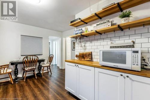 Kitchen with white cabinets, wooden counters, dark hardwood / wood-style floors, and tasteful backsplash - 9 Adam Street, Cambridge, ON 