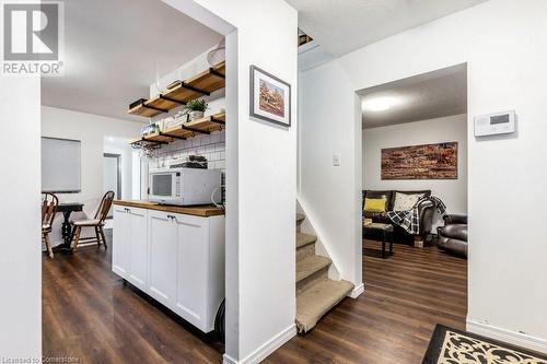 Kitchen with white cabinetry, wooden counters, dark wood-type flooring, and a textured ceiling - 9 Adam Street, Cambridge, ON 