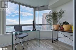 Office with light hardwood / wood-style floors and a wealth of natural light - 