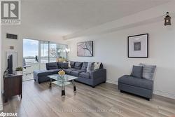 Living room featuring a textured ceiling and light hardwood / wood-style flooring - 