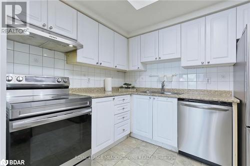 Kitchen featuring light stone countertops, sink, stainless steel appliances, backsplash, and white cabinets - 135 Hillcrest Avenue Unit# 1013, Mississauga, ON - Indoor Photo Showing Kitchen With Double Sink