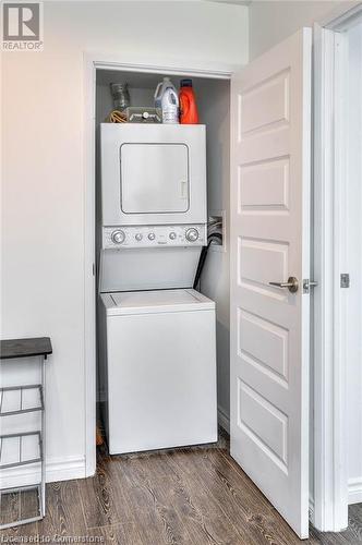 Washroom with dark hardwood / wood-style flooring and stacked washing maching and dryer - 160 King Street N Unit# 901, Waterloo, ON - Indoor Photo Showing Laundry Room