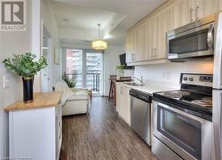 Kitchen with stainless steel appliances, dark wood-type flooring, sink, pendant lighting, and butcher block counters - 