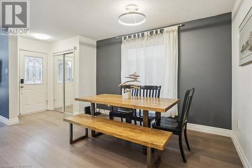 Dining room with wood-type flooring and a textured ceiling - 5021 Bunton Crescent, Burlington, ON - Indoor Photo Showing Dining Room