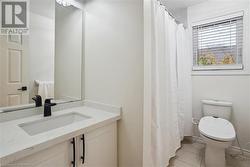 Bathroom featuring tile patterned flooring, vanity, and toilet - 