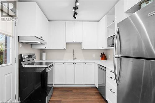 Kitchen featuring rail lighting, stainless steel appliances, sink, dark hardwood / wood-style floors, and white cabinetry - 305 East 24Th Street, Hamilton, ON - Indoor Photo Showing Kitchen