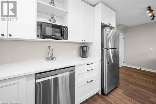 Kitchen with white cabinetry, dark hardwood / wood-style flooring, and stainless steel appliances - 305 East 24Th Street, Hamilton, ON - Indoor Photo Showing Kitchen