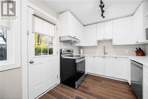 Kitchen featuring dark hardwood / wood-style flooring, rail lighting, stainless steel appliances, sink, and white cabinetry - 305 East 24Th Street, Hamilton, ON - Indoor Photo Showing Kitchen