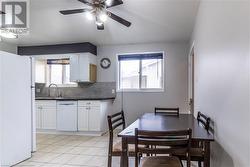 Tiled dining room with sink, a wealth of natural light, and ceiling fan - 