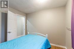 Bedroom featuring a textured ceiling and hardwood / wood-style flooring - 