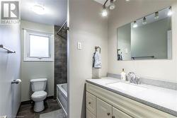 Full bathroom with tile patterned floors, vanity, tiled shower / bath combo, and toilet - 