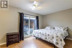 Bedroom with access to outside, ceiling fan, and light hardwood / wood-style flooring - 