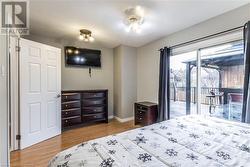 Bedroom with access to exterior, a textured ceiling, and light hardwood / wood-style flooring - 