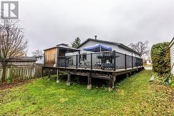 Back of house featuring a deck and a lawn - 