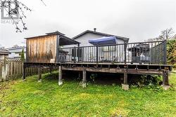 Rear view of house featuring a deck and a yard - 