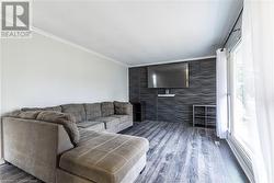 Living room featuring crown molding and wood-type flooring - 