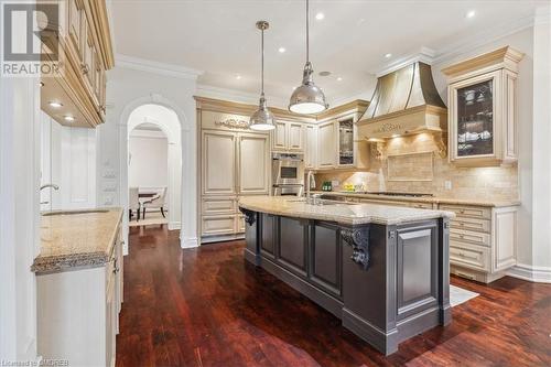 Kitchen featuring sink, light stone counters, dark hardwood / wood-style floors, an island with sink, and custom exhaust hood - 1143 Riverbank Way, Oakville, ON 