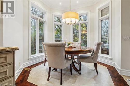 Dining space with light hardwood / wood-style floors, ornamental molding, and a chandelier - 1143 Riverbank Way, Oakville, ON 