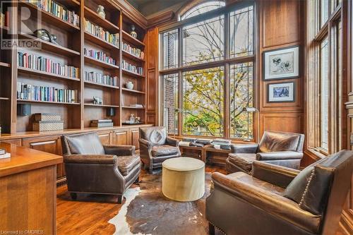 Living area featuring built in shelves, built in desk, and wood-type flooring - 1143 Riverbank Way, Oakville, ON 