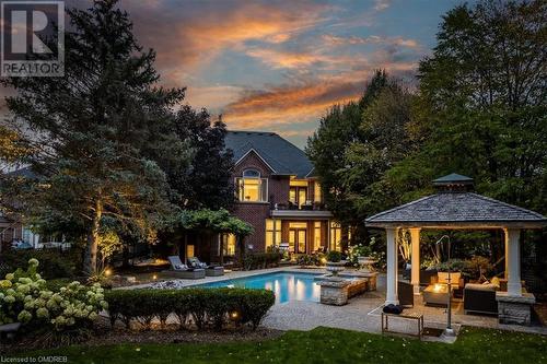 Pool at dusk with a gazebo, an outdoor living space, a patio area, and a lawn - 1143 Riverbank Way, Oakville, ON 