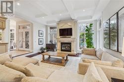 Living room featuring french doors, beamed ceiling, light hardwood / wood-style floors, and coffered ceiling - 