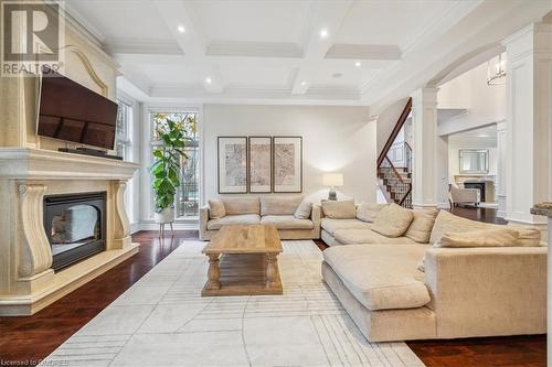 Living room featuring a fireplace, hardwood / wood-style floors, beamed ceiling, and coffered ceiling - 1143 Riverbank Way, Oakville, ON 