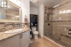 Bathroom featuring tile patterned floors, vanity, an enclosed shower, and decorative backsplash - 