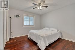 Bedroom featuring a closet, a textured ceiling, dark hardwood / wood-style floors, and ceiling fan - 