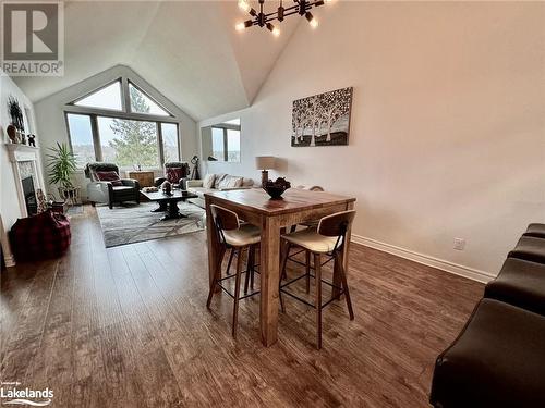 Dining space featuring a notable chandelier, dark hardwood / wood-style floors, and high vaulted ceiling - 231 Grandview/Hilltop Drive, Huntsville, ON - Indoor