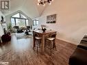 Dining space featuring a notable chandelier, dark hardwood / wood-style floors, and high vaulted ceiling - 231 Grandview/Hilltop Drive, Huntsville, ON  - Indoor 