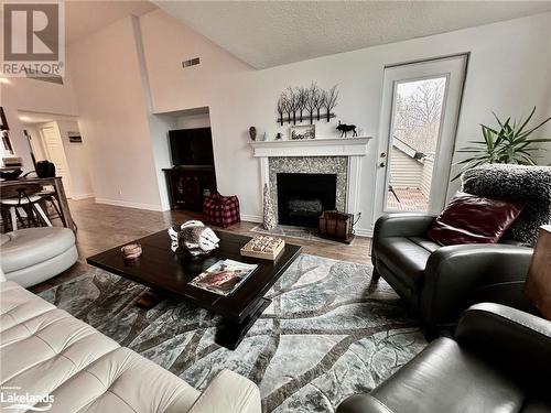 Living room featuring a high end fireplace, high vaulted ceiling, and plenty of natural light - 231 Grandview/Hilltop Drive, Huntsville, ON - Indoor Photo Showing Living Room With Fireplace