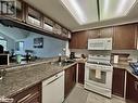 Kitchen with decorative backsplash, white appliances, dark brown cabinetry, sink, and light hardwood / wood-style floors - 231 Grandview/Hilltop Drive, Huntsville, ON  - Indoor Photo Showing Kitchen With Double Sink 