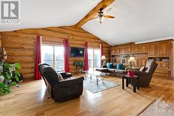 Living room built-in solid wood wall storage unit and two patio doors to deck overlooking lake-pond - 