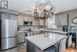 Kitchen with a textured ceiling, a center island, stainless steel appliances, and sink - 