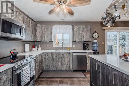 Kitchen featuring a wealth of natural light, sink, stainless steel appliances, and dark tile patterned flooring - 727 Zermatt Drive, Waterloo, ON - Indoor Photo Showing Kitchen