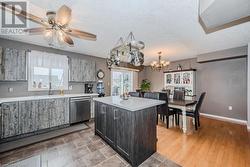 Kitchen with sink, dishwasher, a center island, light hardwood / wood-style flooring, and pendant lighting - 