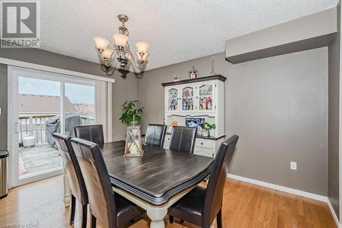 Dining room featuring light hardwood / wood-style floors, a textured ceiling, and an inviting chandelier - 727 Zermatt Drive, Waterloo, ON - Indoor Photo Showing Dining Room