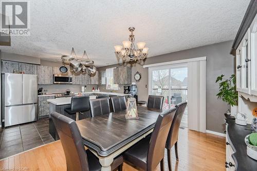 Dining space with sink, a chandelier, a textured ceiling, and light wood-type flooring - 727 Zermatt Drive, Waterloo, ON - Indoor Photo Showing Dining Room