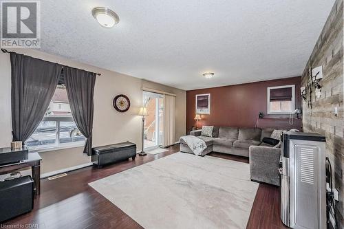 Living room with dark hardwood / wood-style floors, a healthy amount of sunlight, and a textured ceiling - 727 Zermatt Drive, Waterloo, ON - Indoor Photo Showing Living Room