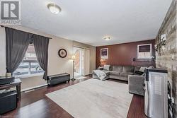 Living room with dark hardwood / wood-style floors, a healthy amount of sunlight, and a textured ceiling - 