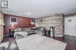 Living room with wood walls, dark hardwood / wood-style flooring, and a textured ceiling - 