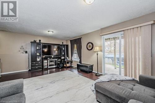 Living room featuring a textured ceiling and dark hardwood / wood-style floors - 727 Zermatt Drive, Waterloo, ON - Indoor