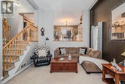 Living room with light colored carpet and a notable chandelier - 