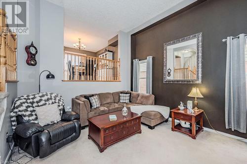 Living room with carpet floors, a textured ceiling, and an inviting chandelier - 727 Zermatt Drive, Waterloo, ON - Indoor Photo Showing Living Room