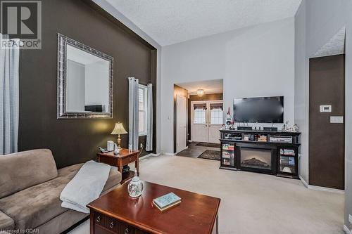 Carpeted living room with french doors and a textured ceiling - 727 Zermatt Drive, Waterloo, ON - Indoor