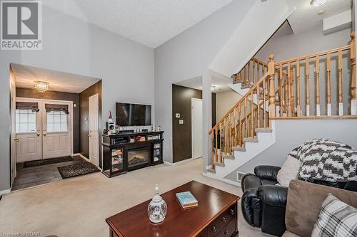 Carpeted living room with a textured ceiling, a high ceiling, and french doors - 727 Zermatt Drive, Waterloo, ON - Indoor